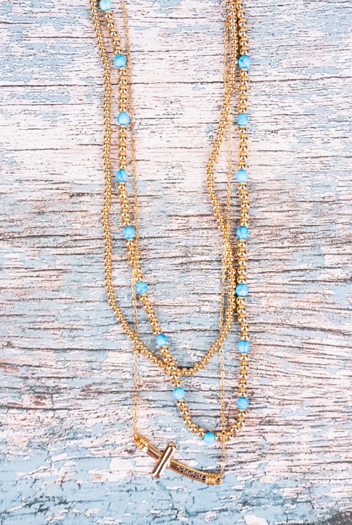 Turquoise gold tone cross layered necklace